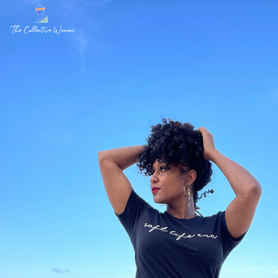 mixed african american and indian woman with curly hair on beach wearing soft life era cursive shirt in heather black
